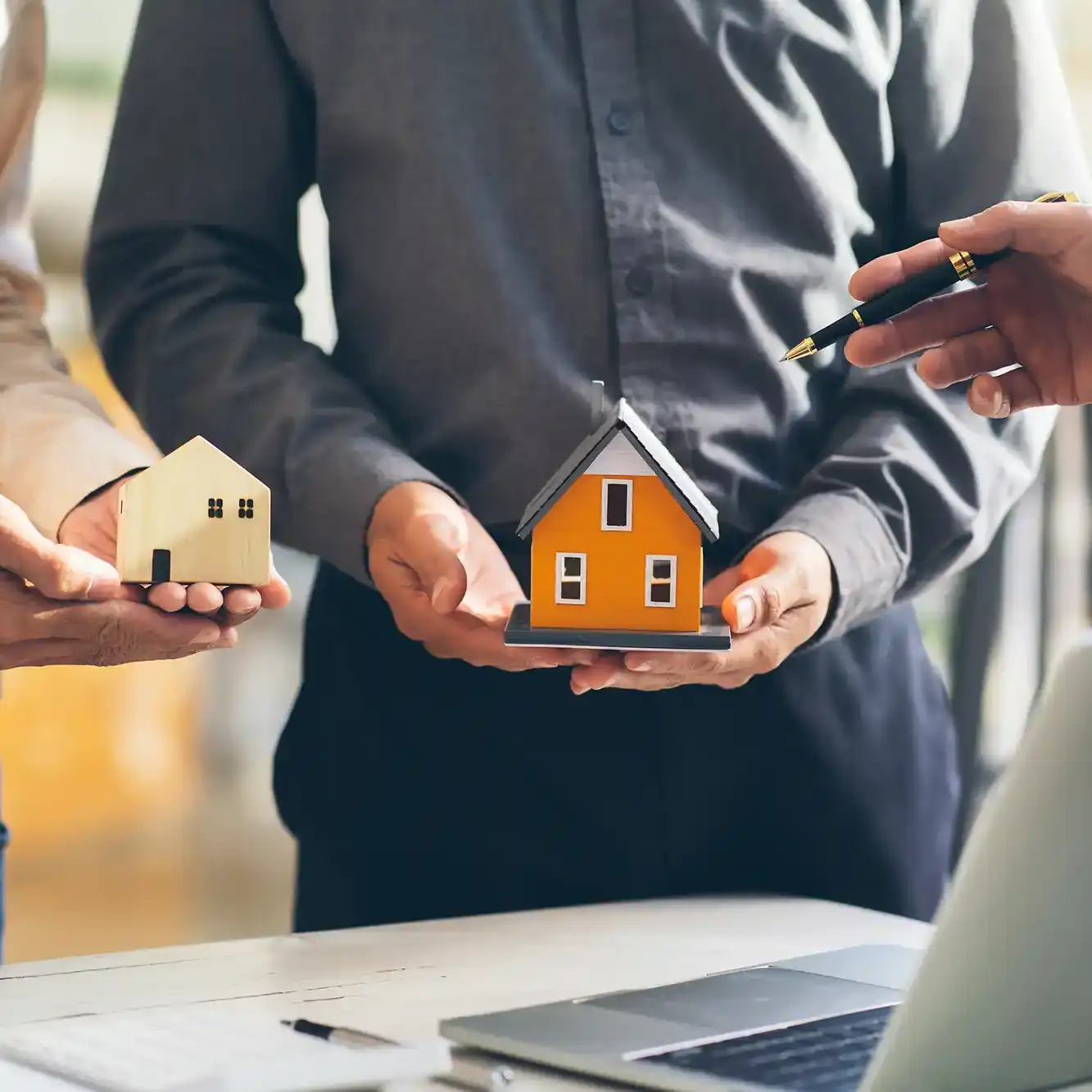 Immobilien verkaufen house-model-with-agent-and-customer-discussing-fo